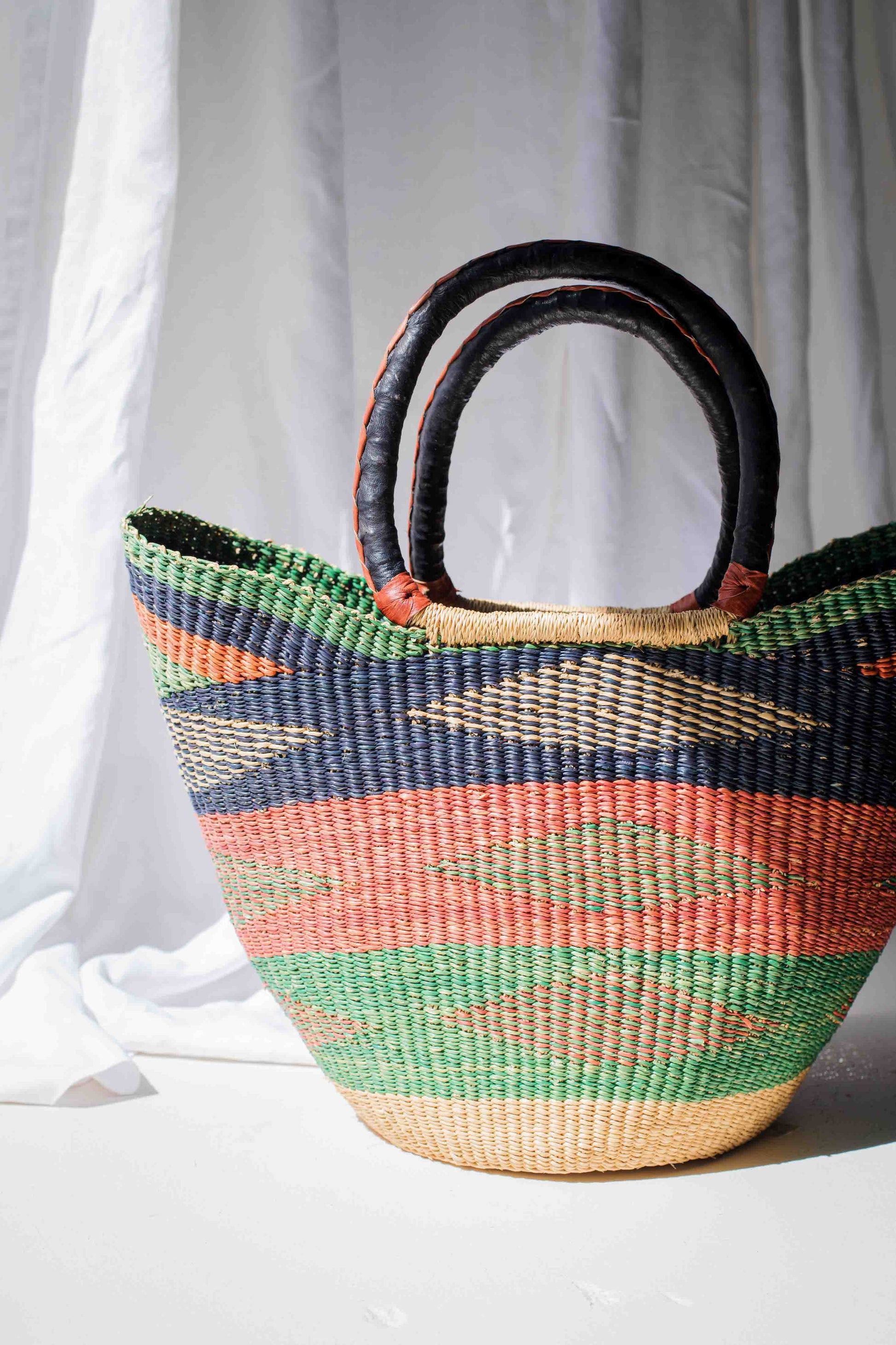 Woven basket with colorful pattern on a white background