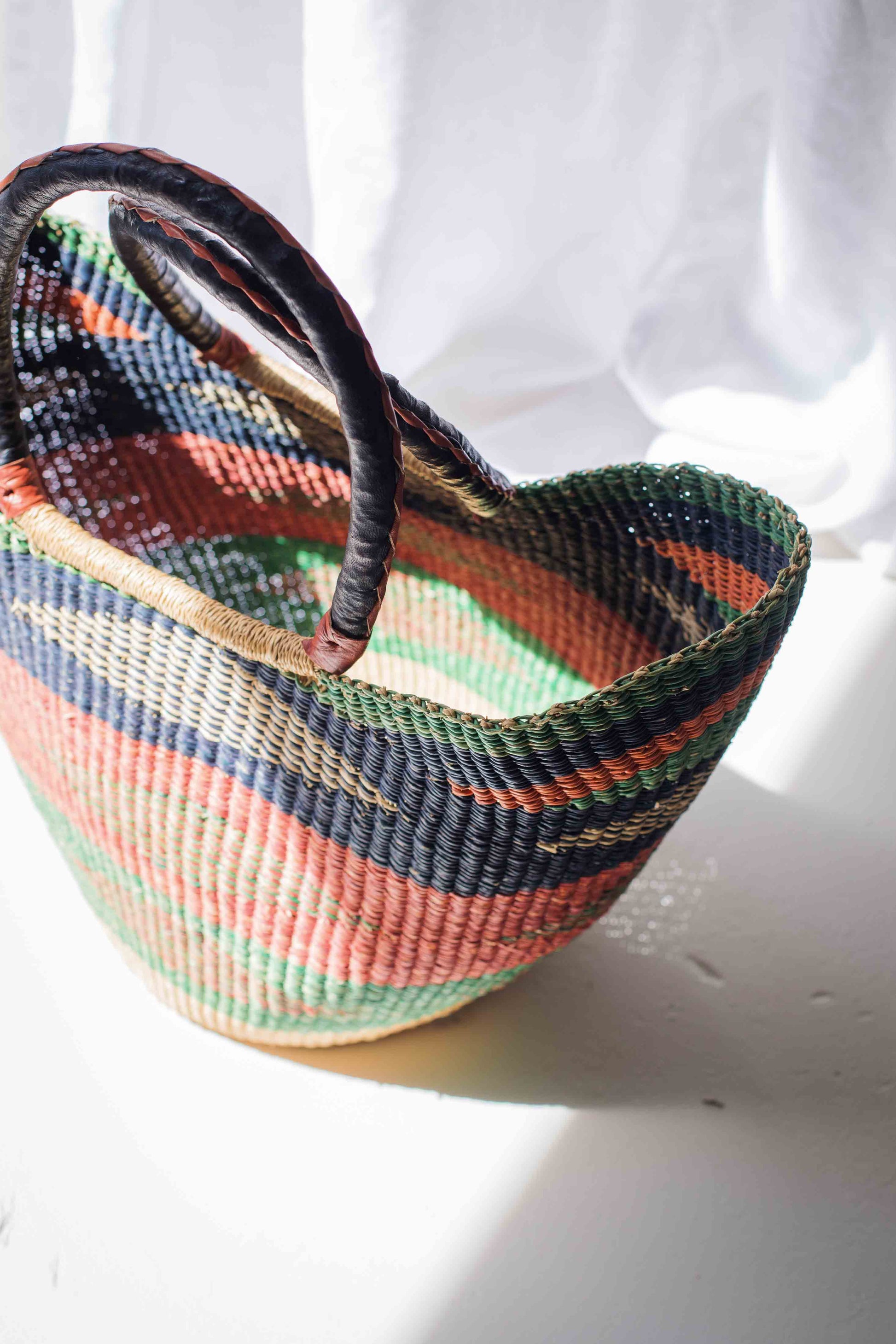 Multicolored woven basket on a white surface