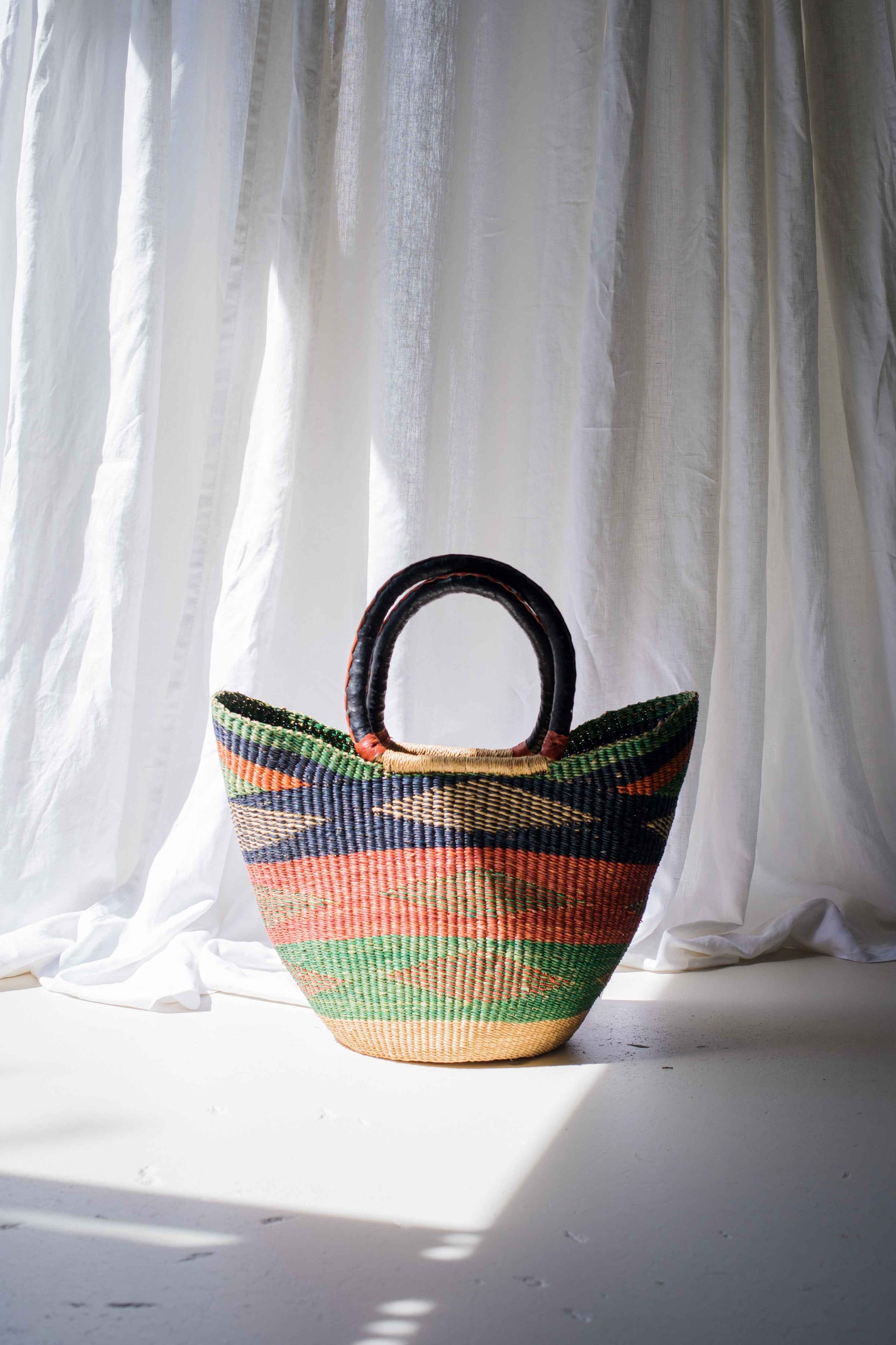 Woven basket with colorful patterns on a white background