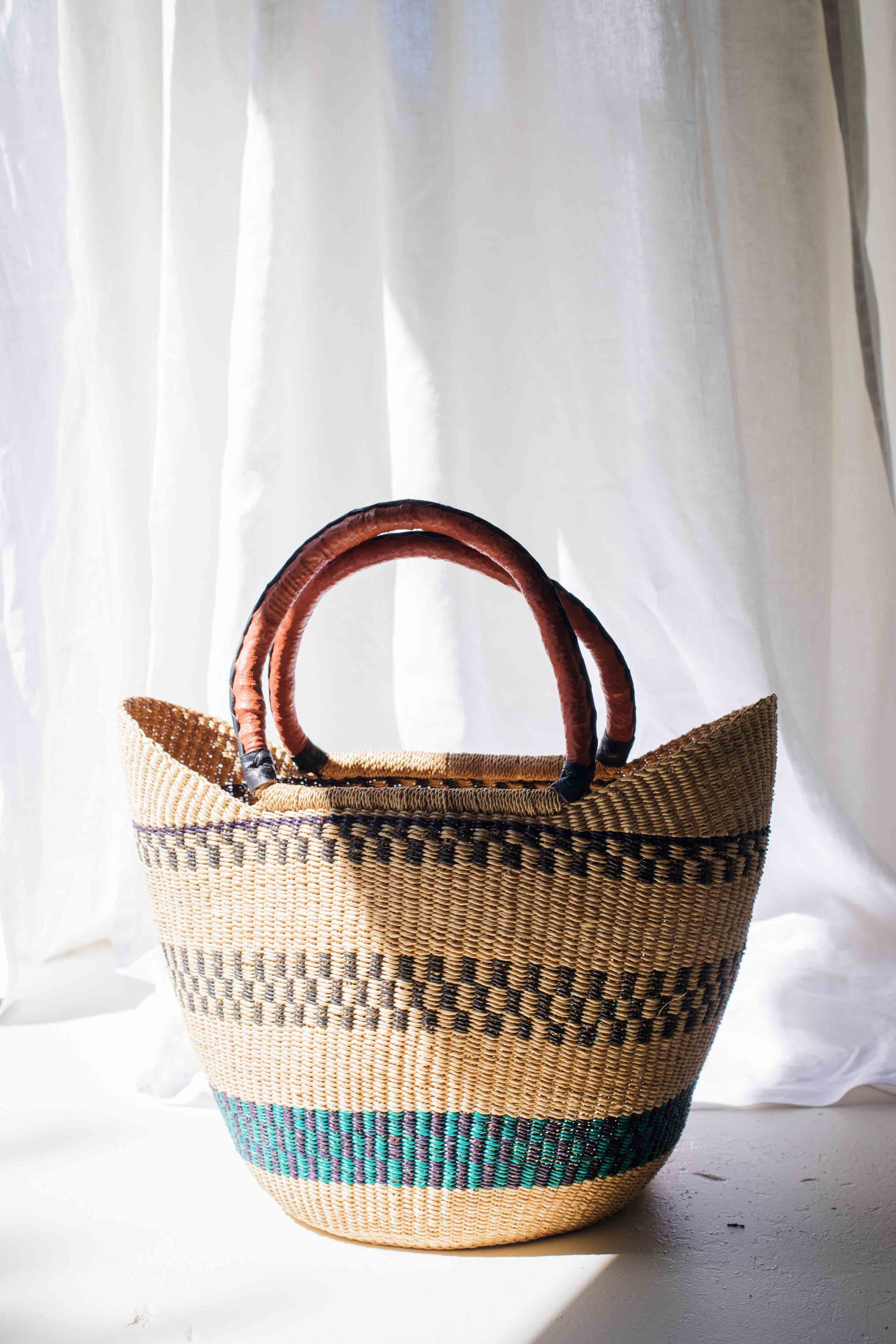 Woven basket with striped pattern on a white background