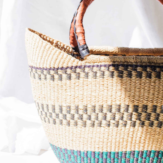 Woven basket with wooden handles on a white background