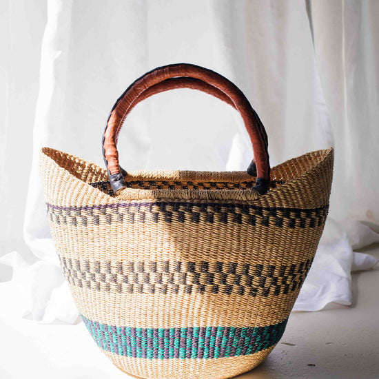 Woven basket with a wooden handle on a white background