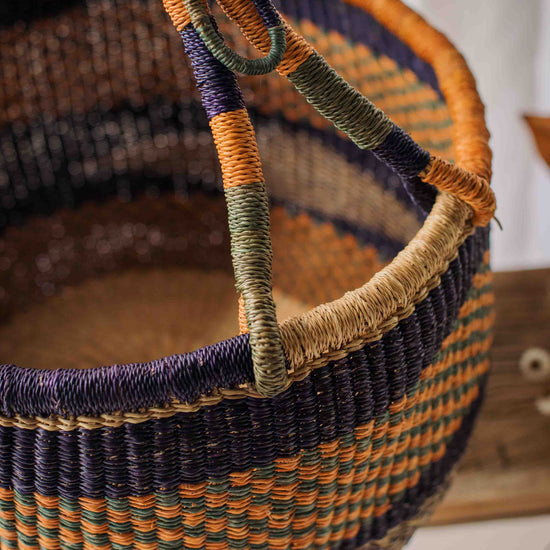 Woven basket with multicolored handle on a neutral background
