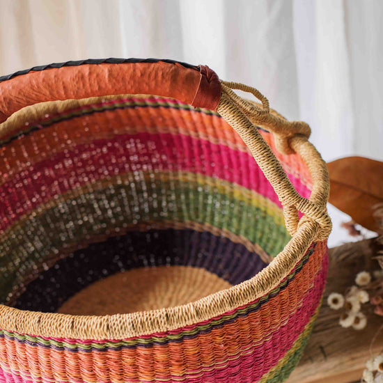Colorful woven basket with a striped pattern on a white background