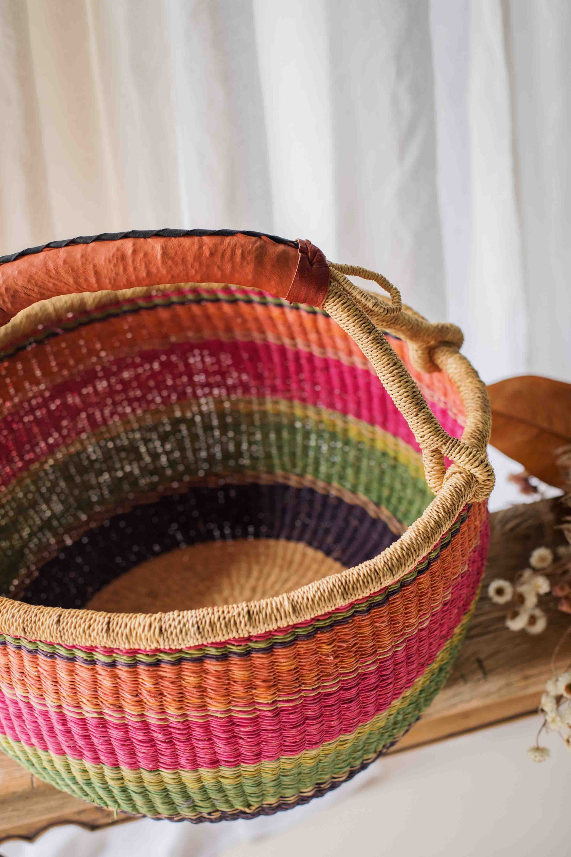 Colorful woven basket with a striped pattern on a white background