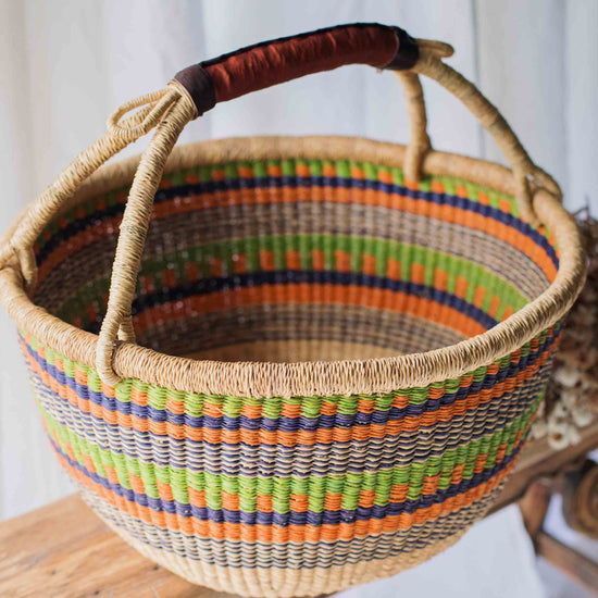 Woven basket with colorful stripes on a wooden surface