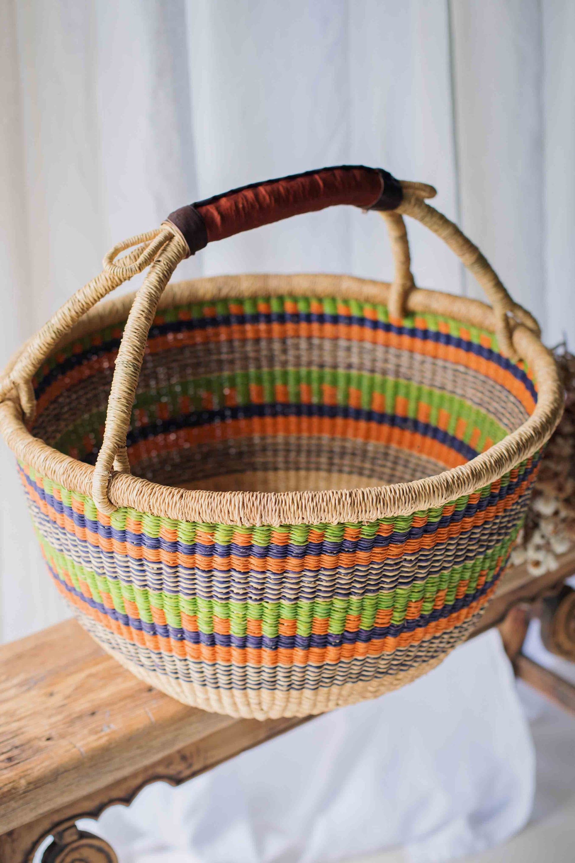 Woven basket with colorful stripes on a wooden surface