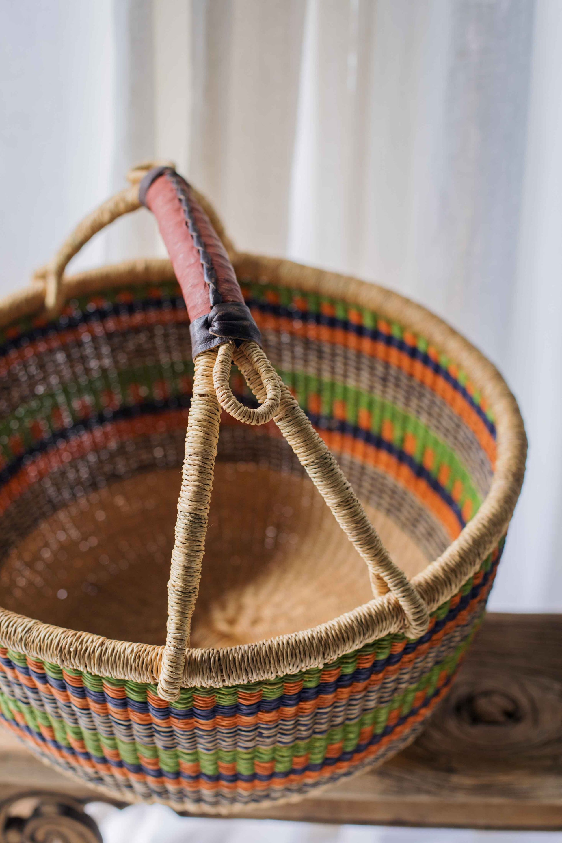 Woven basket with colorful rim on a wooden surface