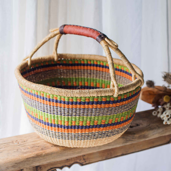 Colorful woven basket with a striped pattern on a wooden surface.