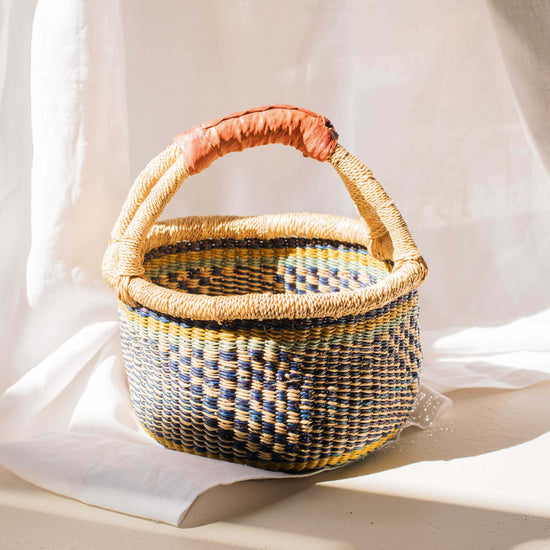 Woven basket with a handle on a light background