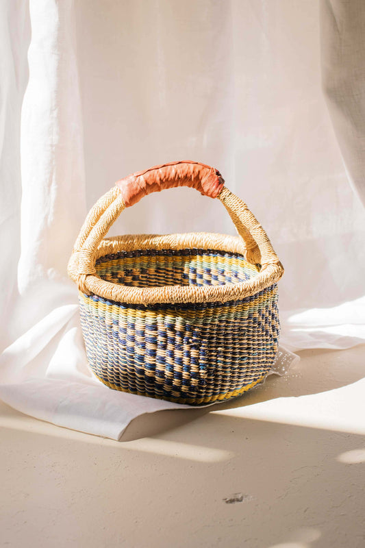 Woven basket with a handle on a light background