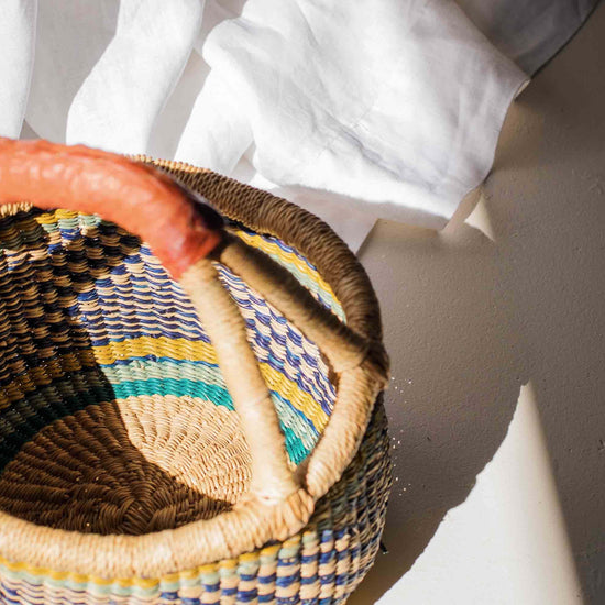 Woven basket with colorful pattern on a white surface