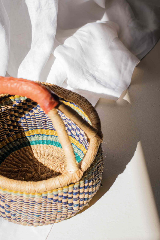 Woven basket with colorful pattern on a white surface