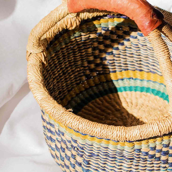 Woven basket with a carrot on a white surface