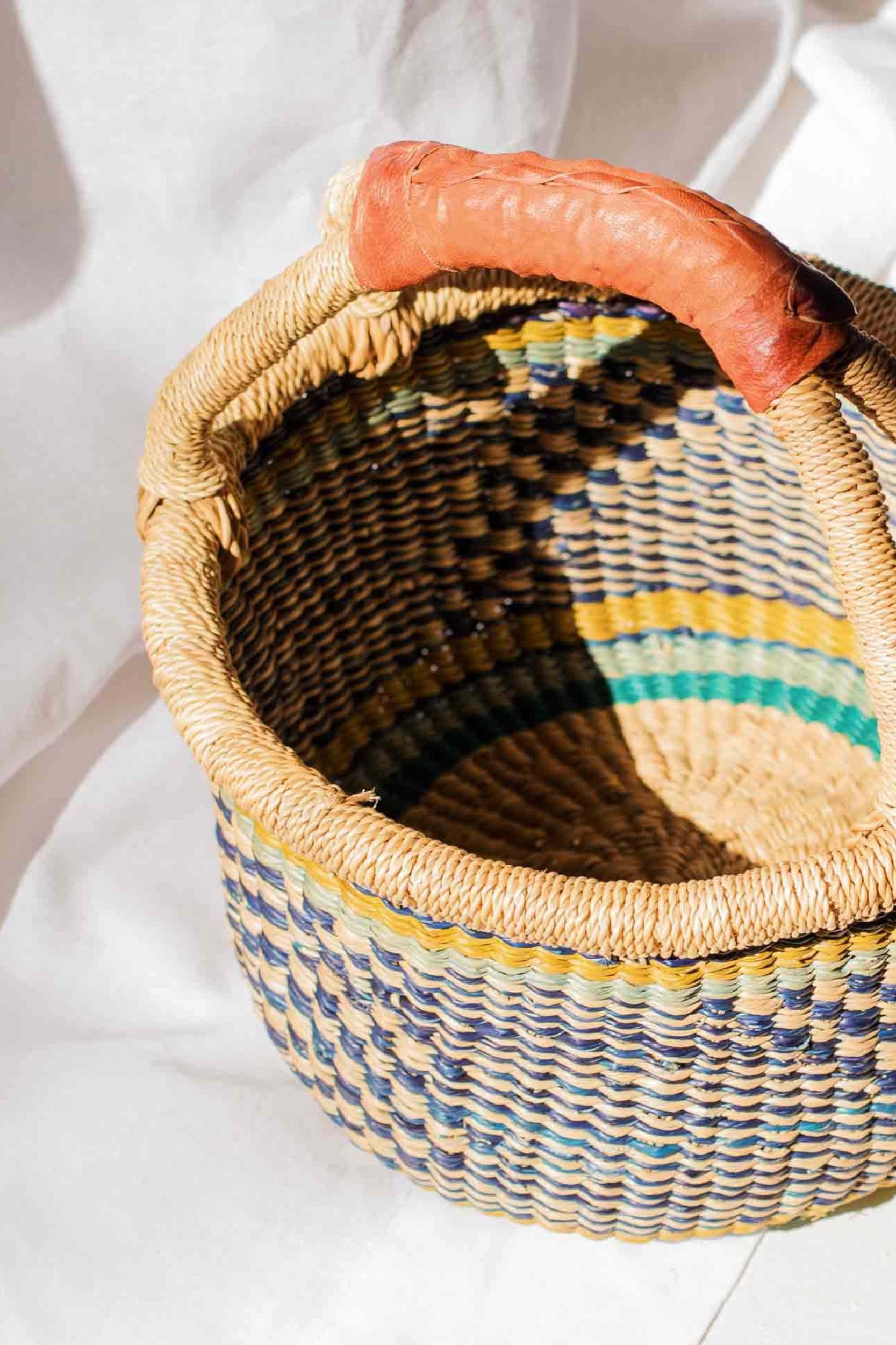 Woven basket with a carrot on a white surface