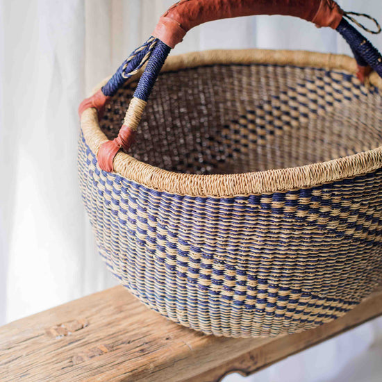 Woven basket with decorative handles on a wooden surface