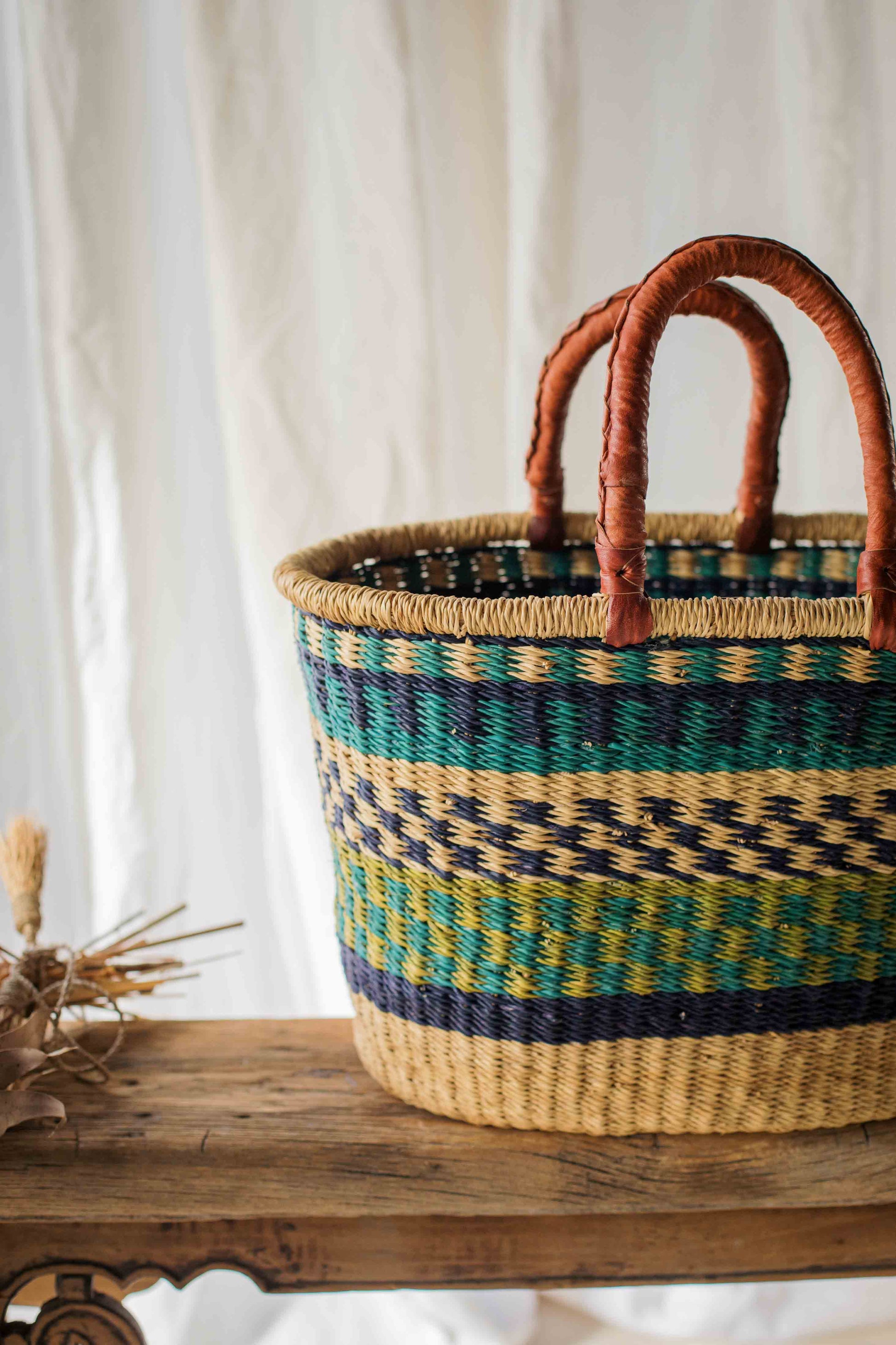 Woven basket with striped pattern on a wooden surface