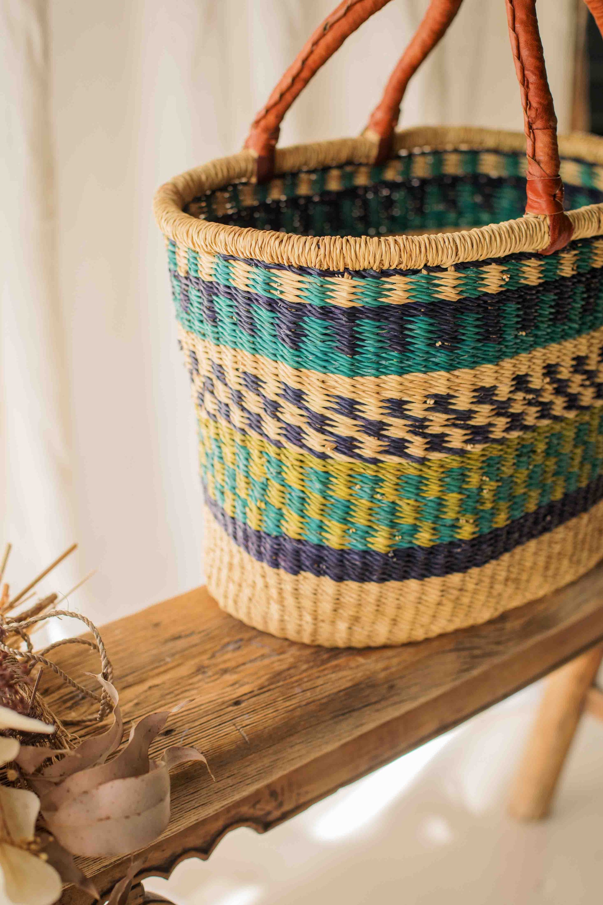 Woven basket with colorful pattern on a wooden surface