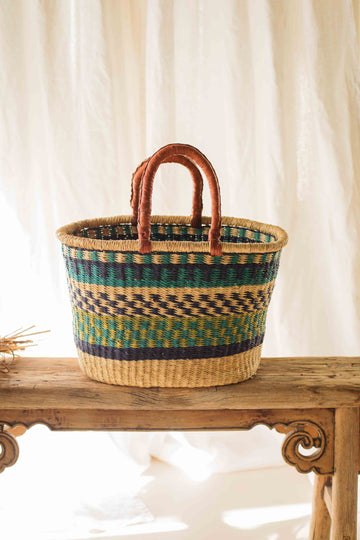 Woven basket with striped pattern on a wooden surface