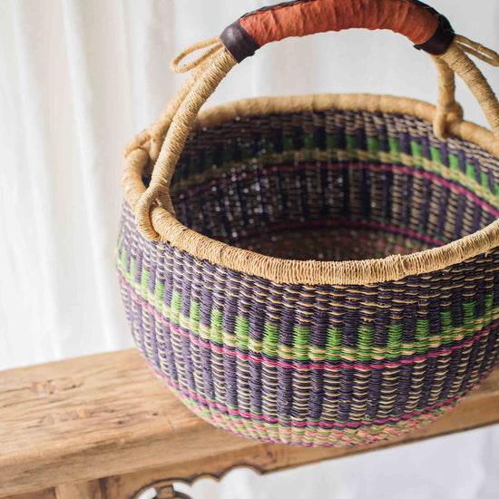 Woven basket with colorful patterns on a wooden surface