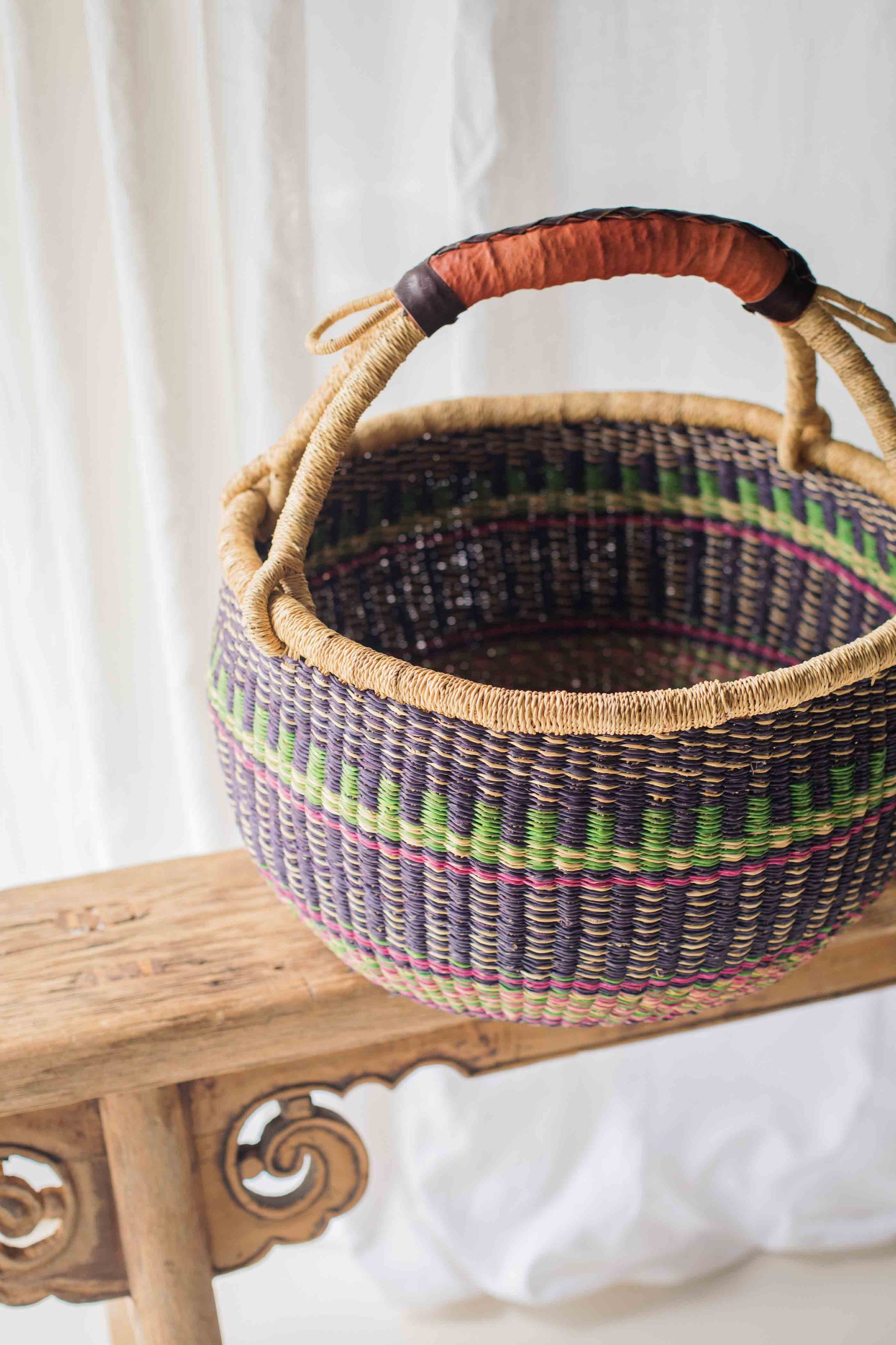 Woven basket with colorful patterns on a wooden surface