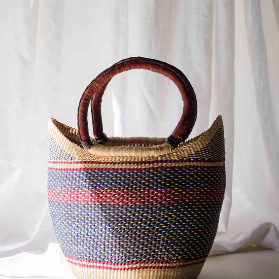 Woven basket with striped pattern against a white curtain background