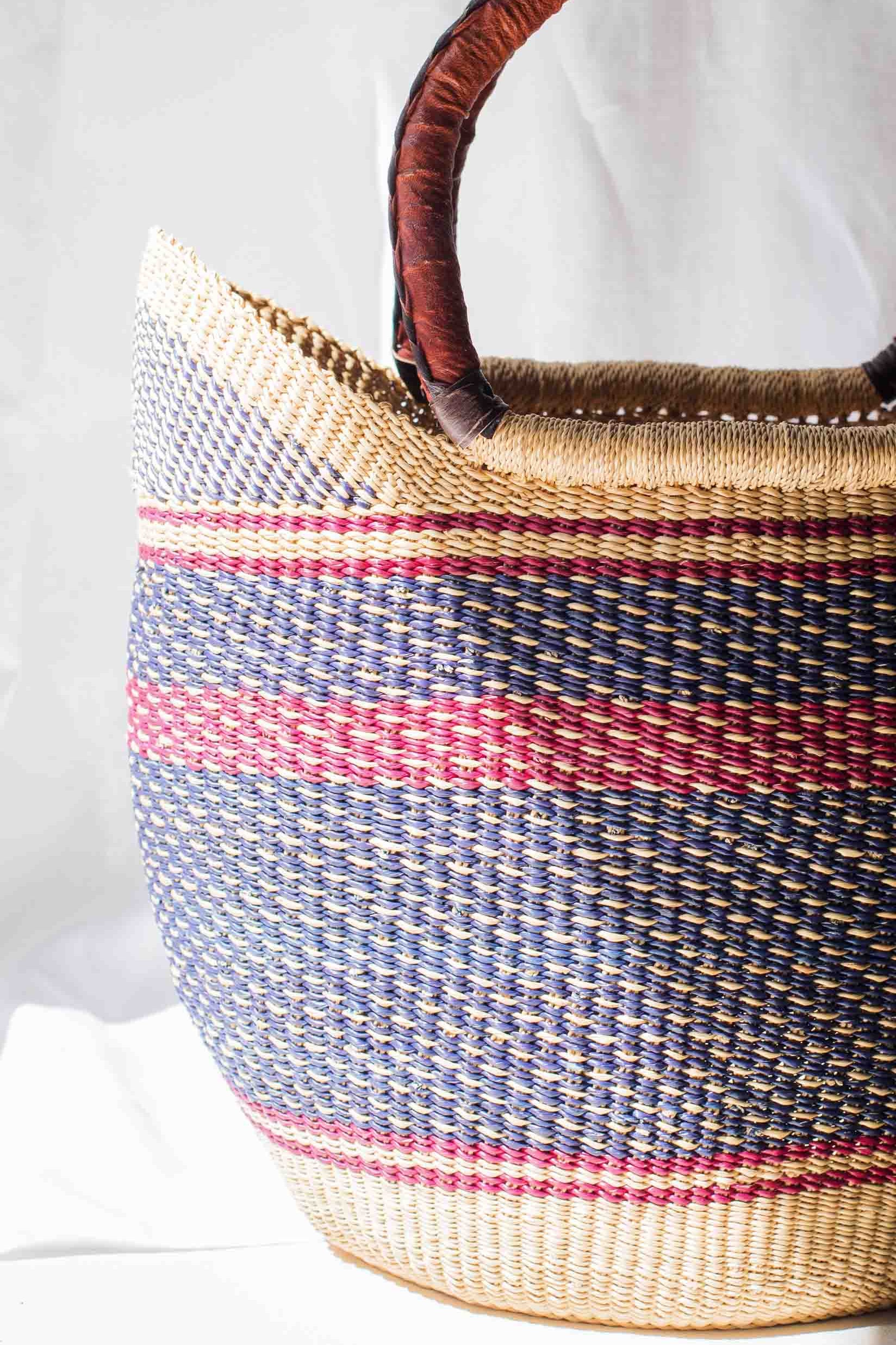 Woven basket with striped pattern and wooden handles on a white background