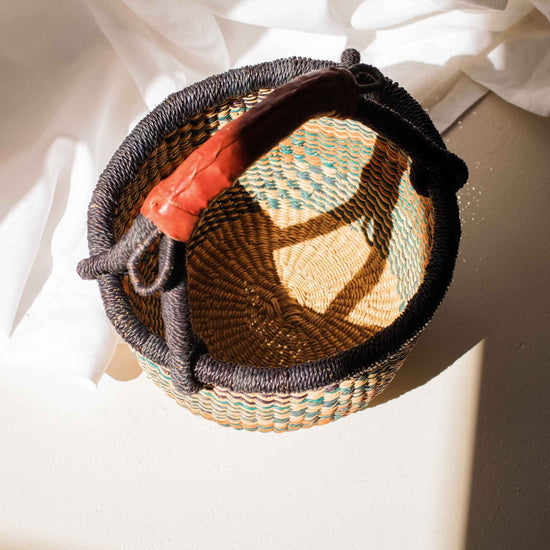 Woven basket with a colorful interior on a light surface
