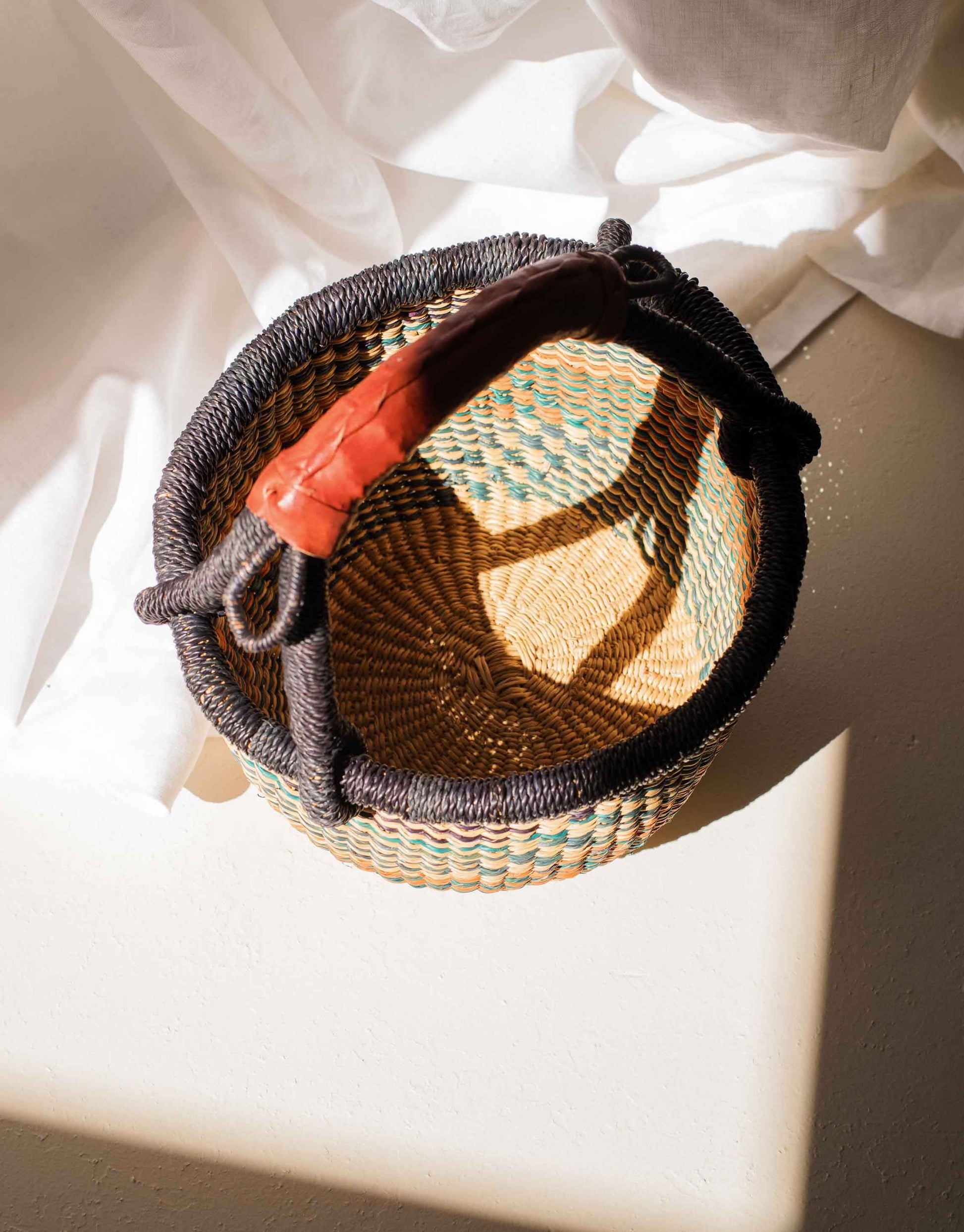 Woven basket with a colorful interior on a light surface