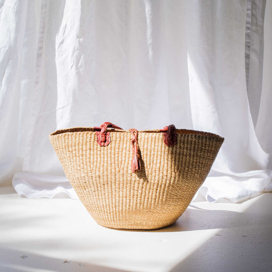 Woven basket with tassels on a light background