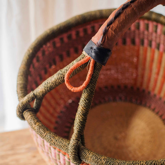 Woven basket with a handle on a wooden surface
