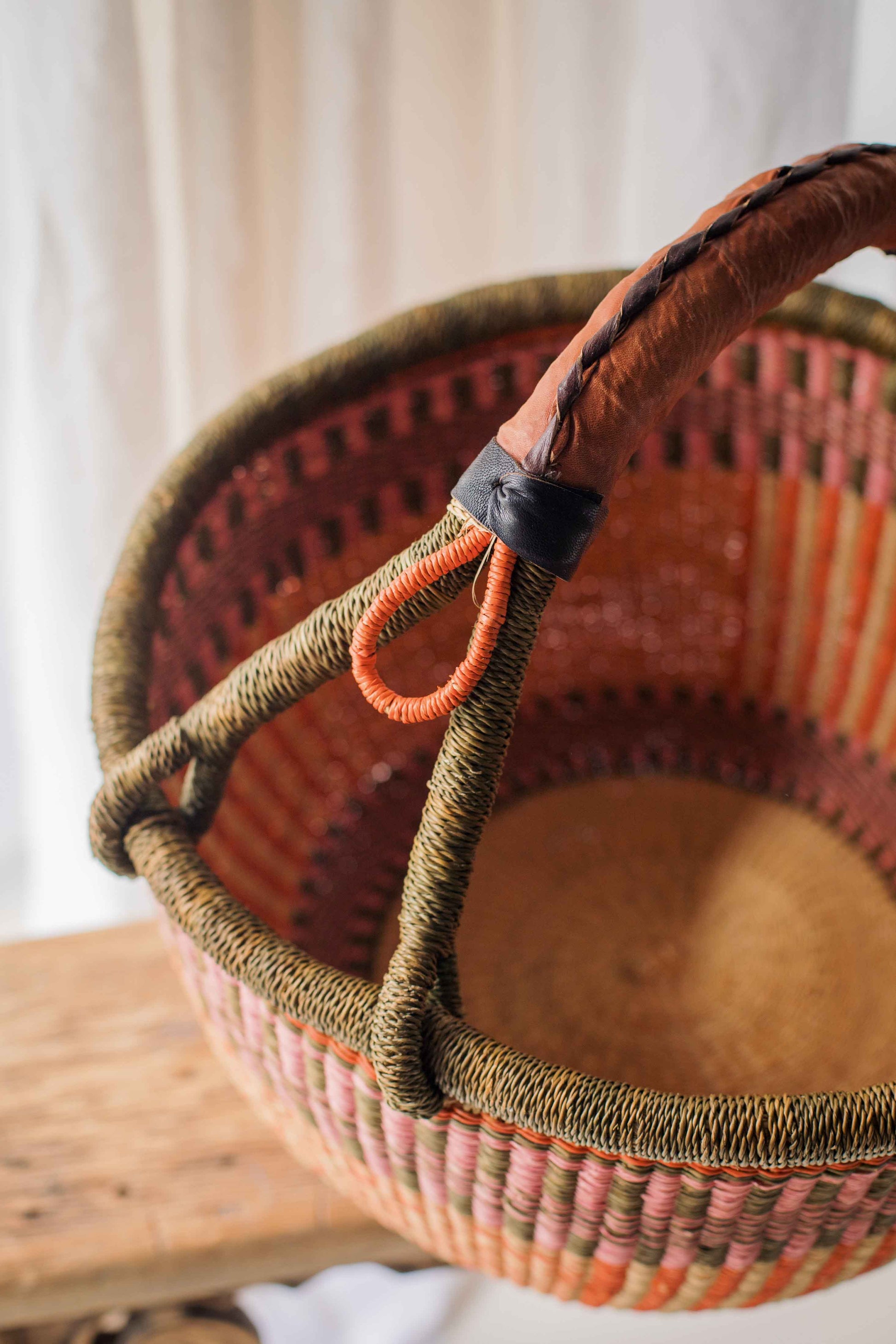 Woven basket with a handle on a wooden surface