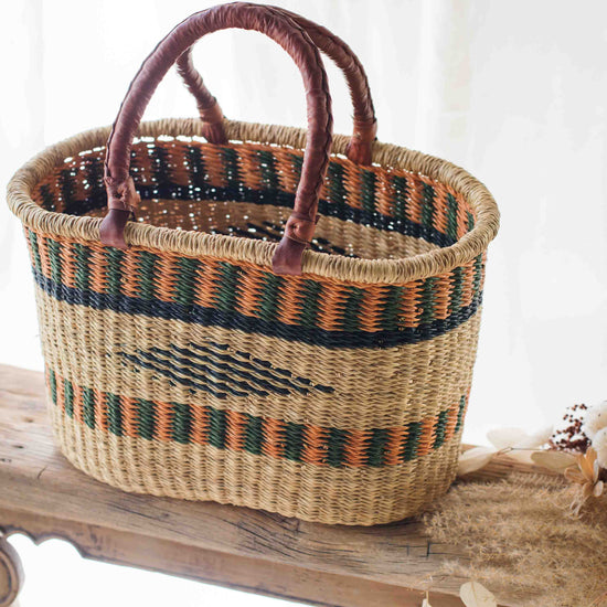 Woven basket with patterned handles on a wooden surface