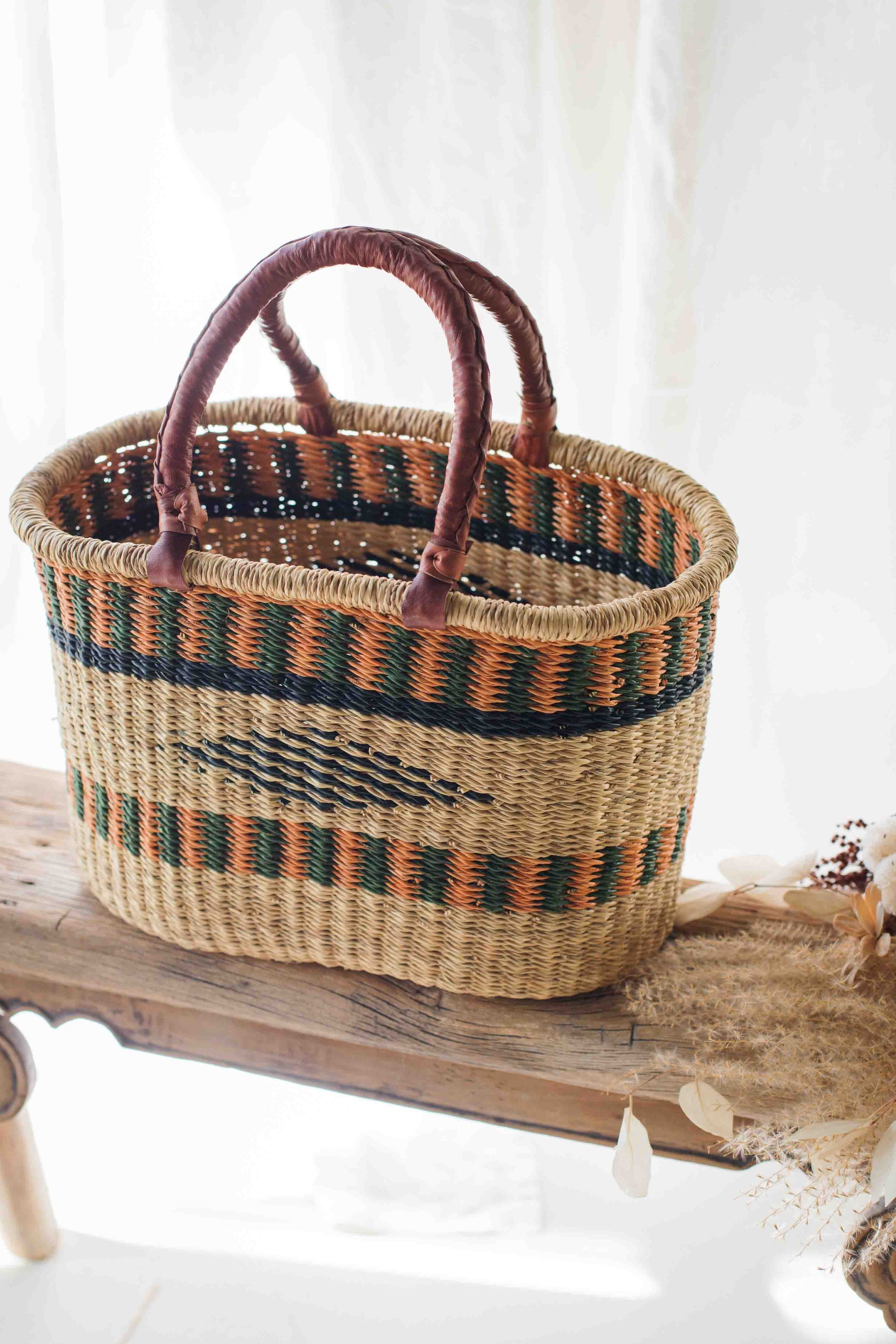 Woven basket with patterned handles on a wooden surface