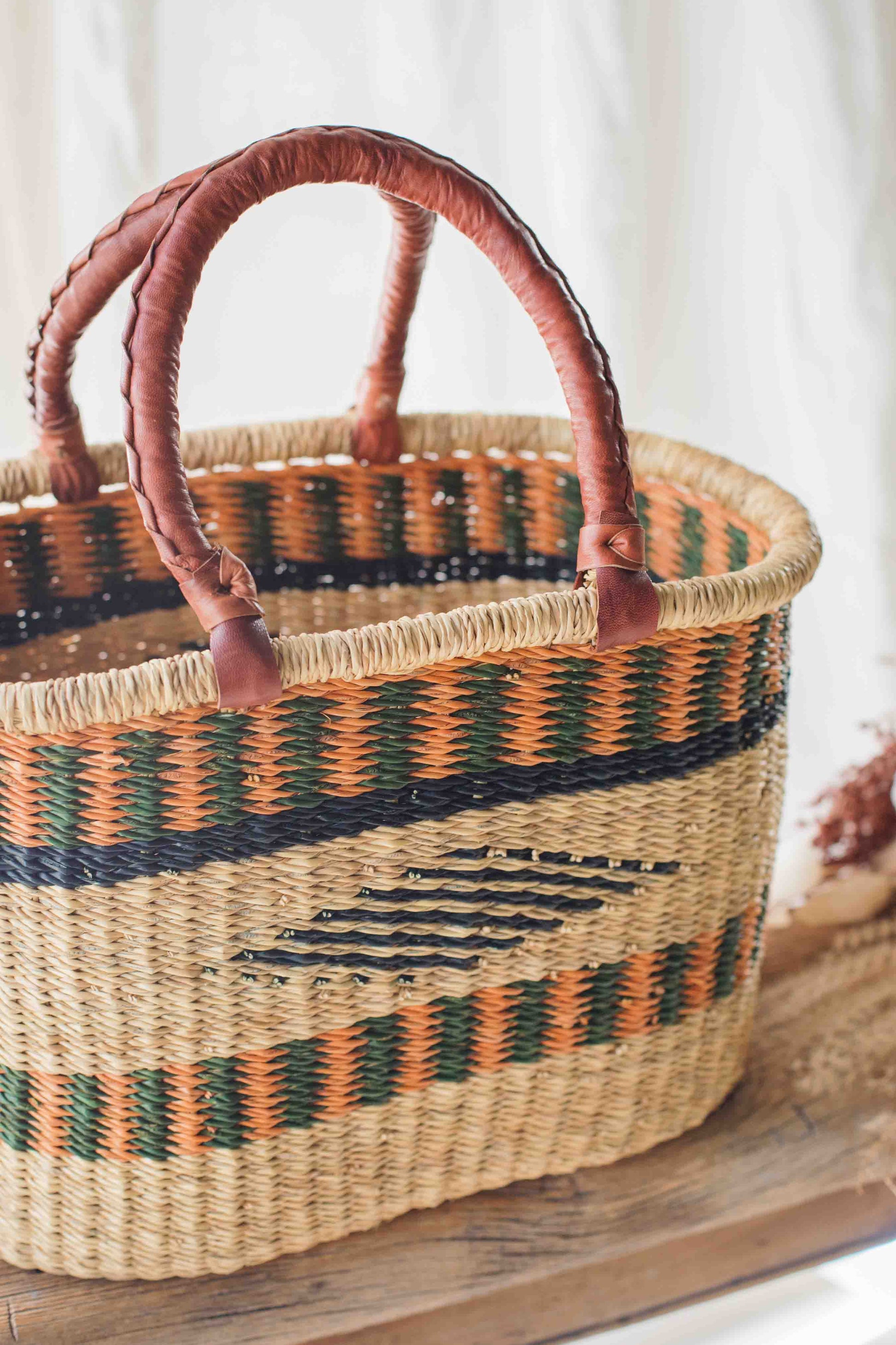 Woven basket with striped pattern on a wooden surface