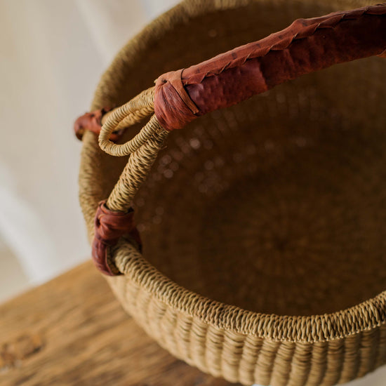 Woven basket with a handle on a wooden surface