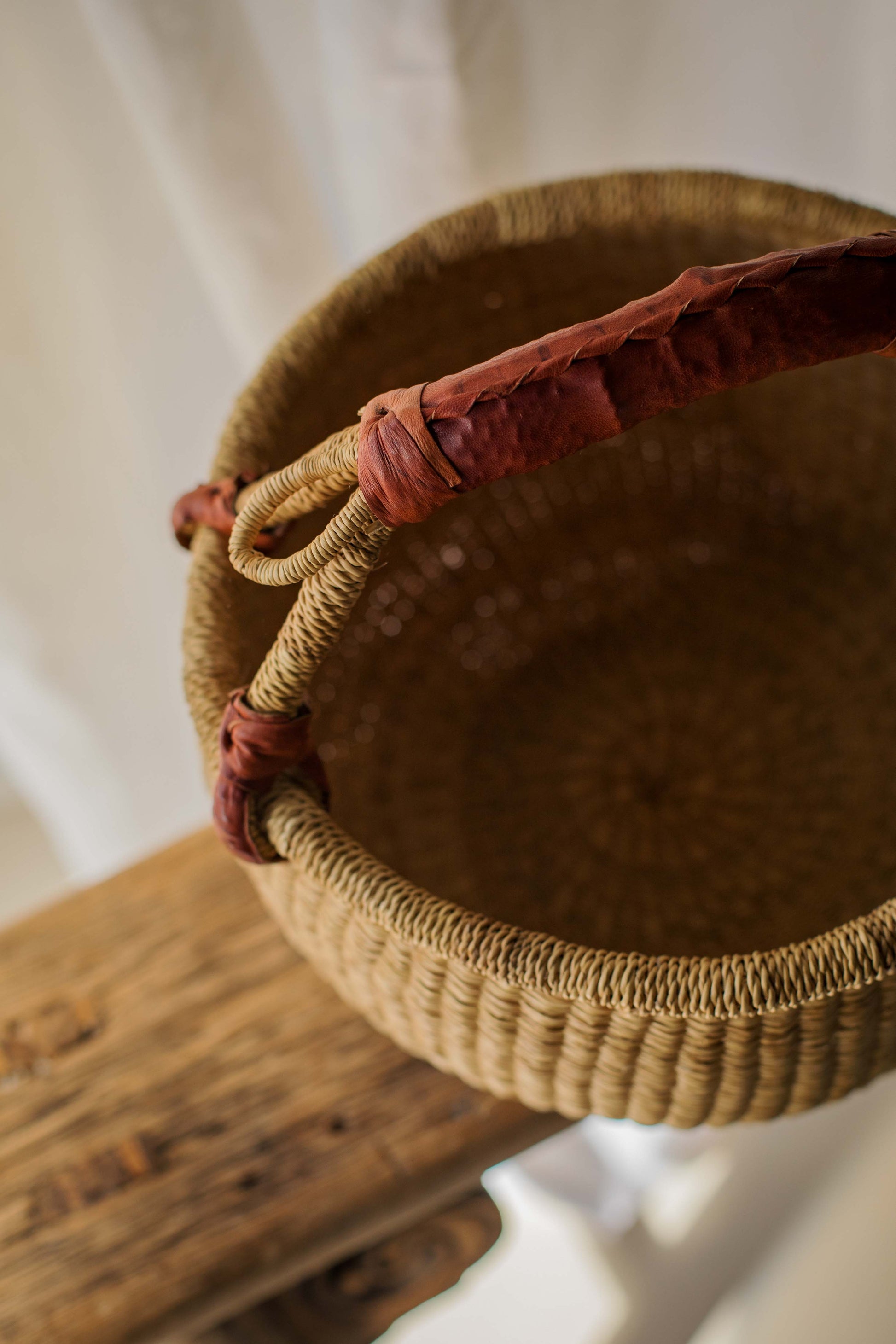 Woven basket with a handle on a wooden surface
