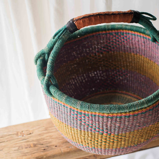 Woven basket with a colorful pattern on a wooden surface