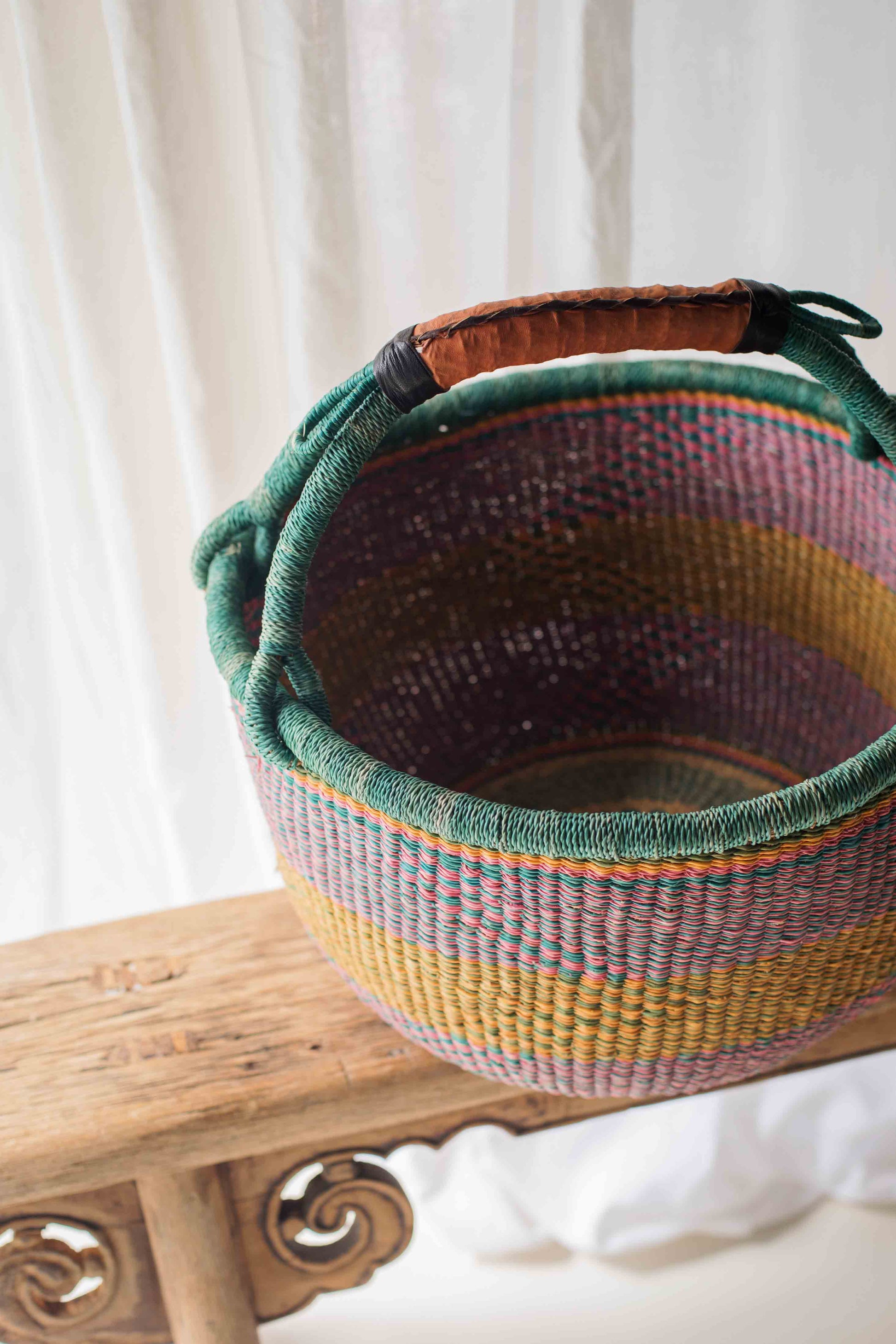 Woven basket with a colorful pattern on a wooden surface