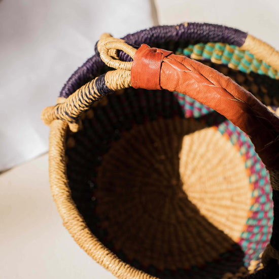 Woven basket with colorful patterns on a light background