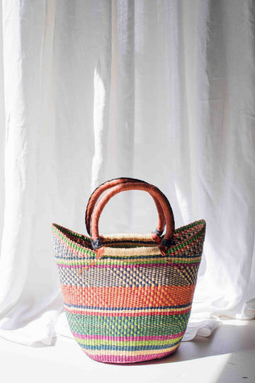 Colorful woven basket with wooden handles on a white background