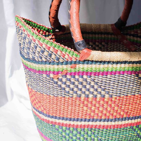 Colorful woven basket with wooden handles on a white background