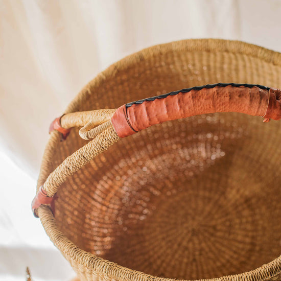 Woven basket with a red interior on a neutral background
