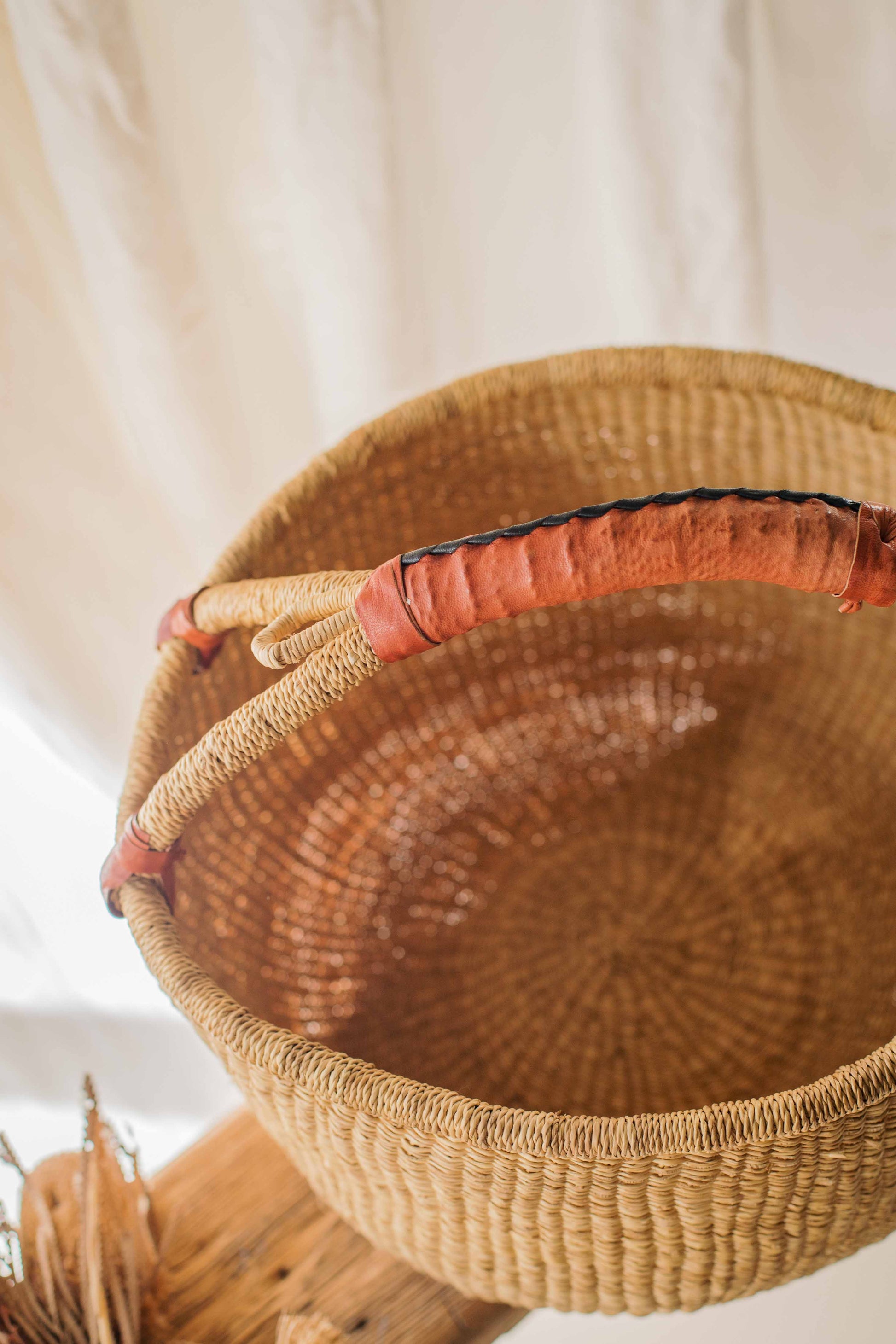 Woven basket with a red interior on a neutral background