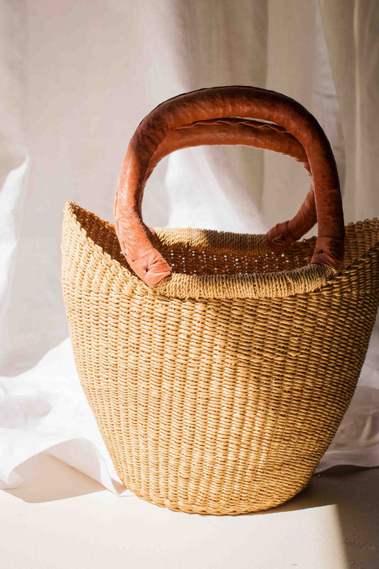 Woven basket with wooden handle on a white background