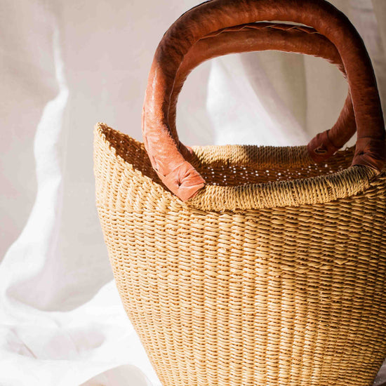Woven handbag with wooden handles on a white background