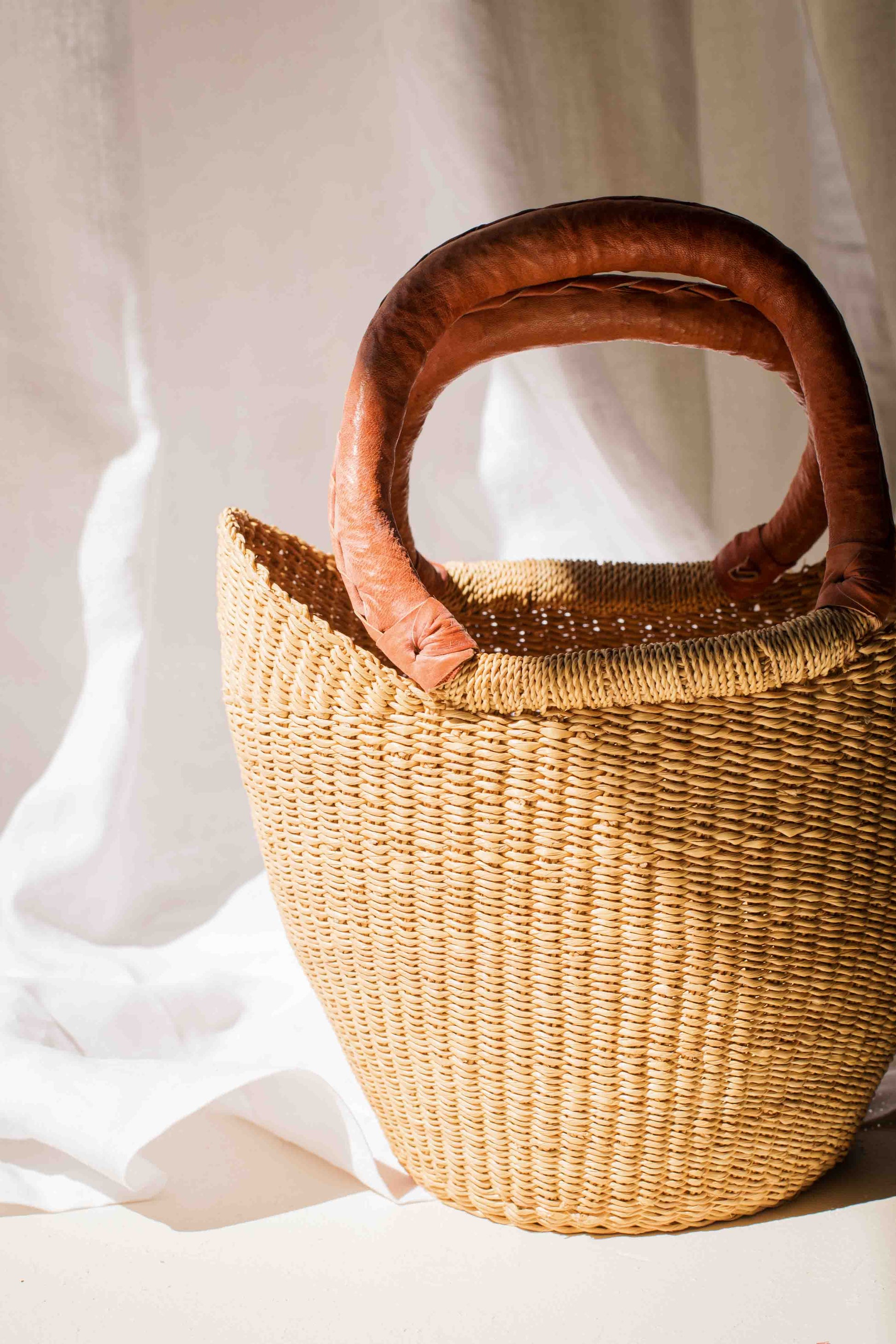 Woven handbag with wooden handles on a white background