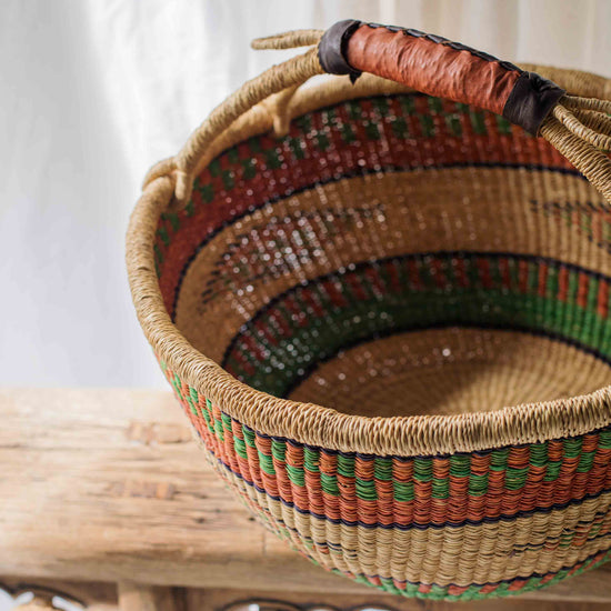 Woven basket with colorful patterns on a wooden surface