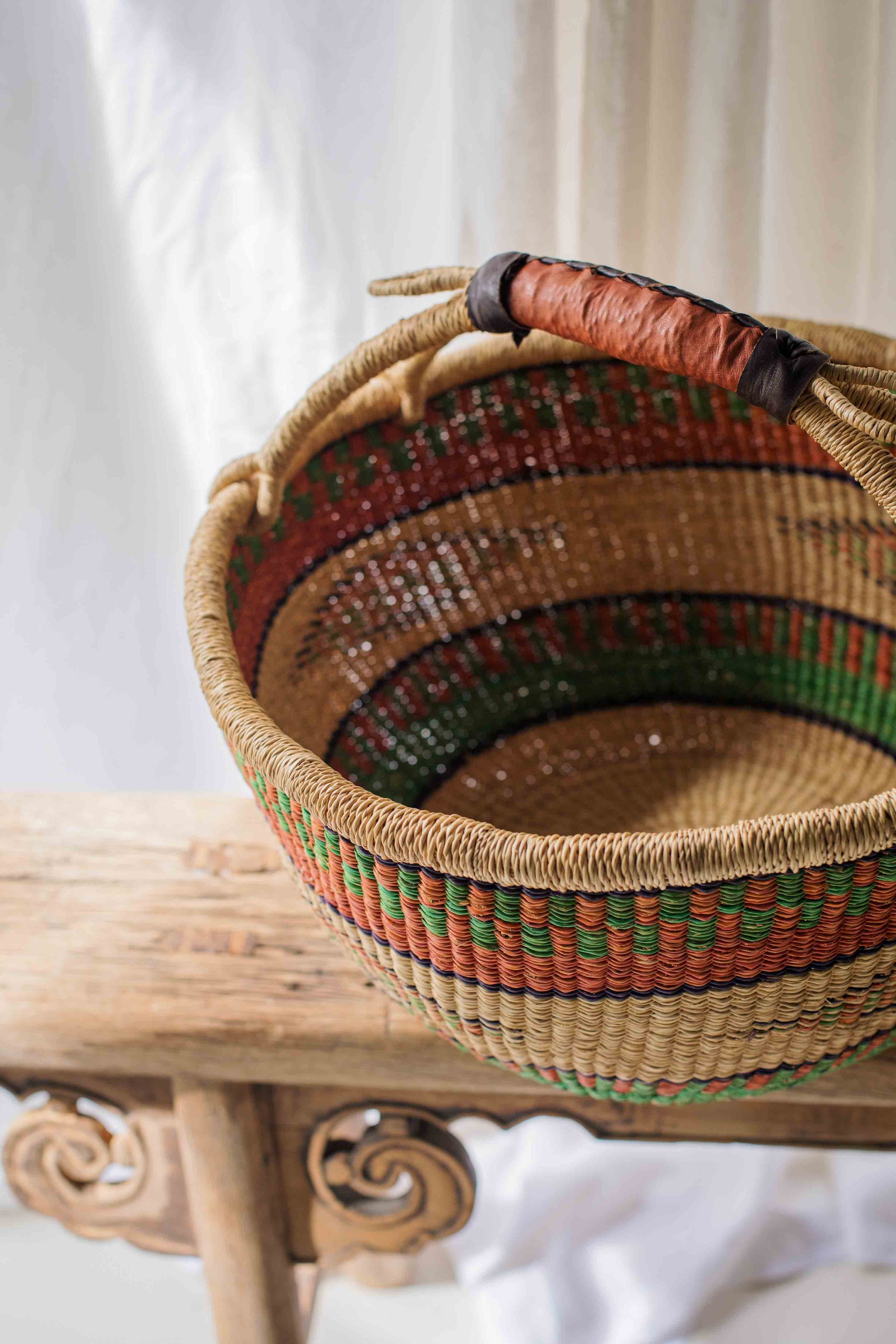 Woven basket with colorful patterns on a wooden surface