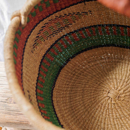 Close-up of a woven basket with a hand holding it